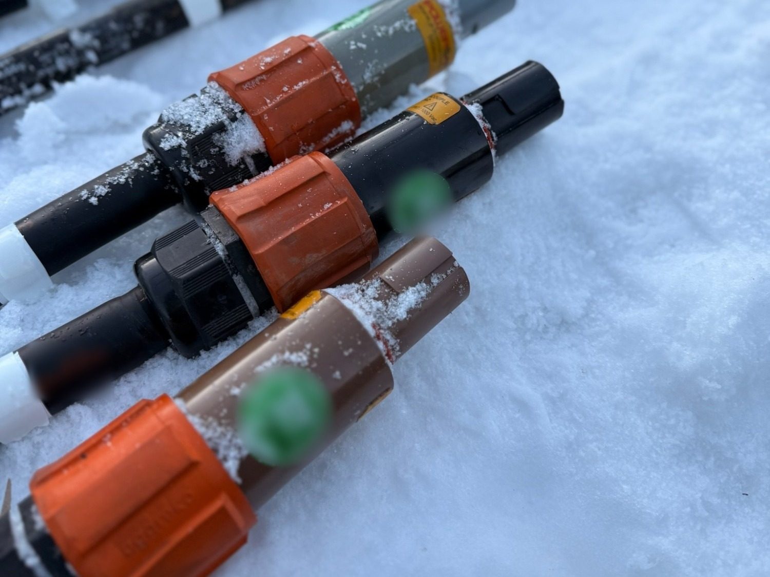 Powerlock connectors with coloured rings lying in the snow